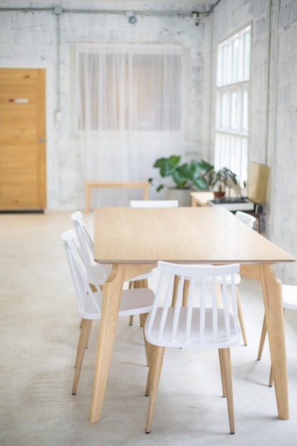 Foto cadeiras brancas e mesa de madeira na sala