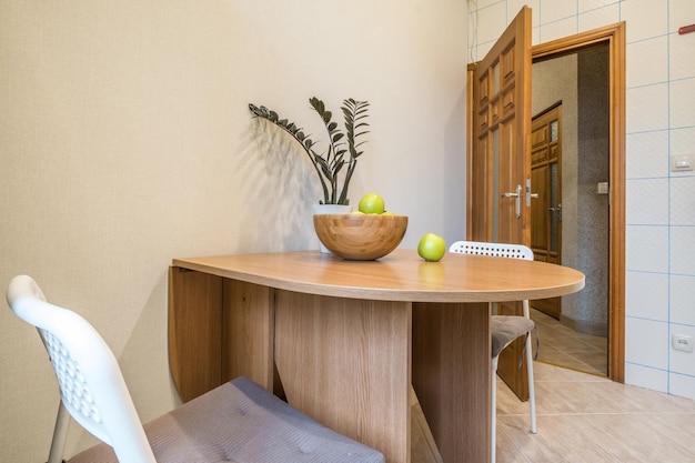 Cadeiras confortáveis e mesa com flores no interior da moderna sala de estar ou cozinha