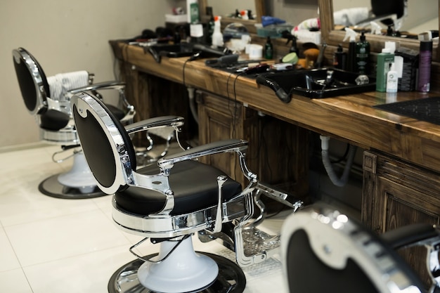 Cadeiras de barbeiro elegantes e modernas com interior preto e cinza de barbearia