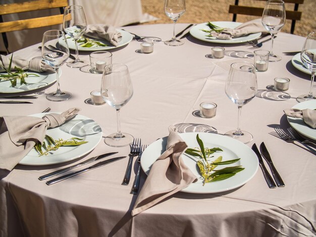 Cadeiras de conceito de banquete de casamento e mesa redonda para convidados servidos com talheres e flores e crocker