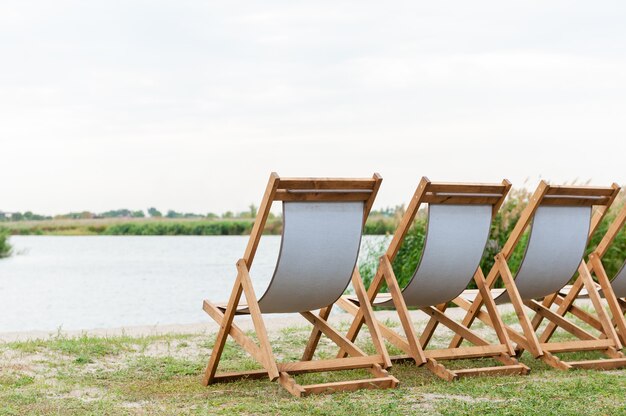 Cadeiras de madeira vazias na praia fluvial para relaxar