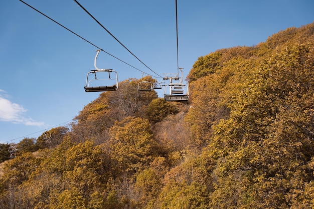 Cadeiras de teleférico vazias da estância de esqui de montanha em dia de outono