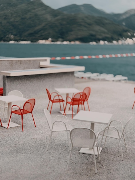 Cadeiras e mesas vazias à beira da piscina