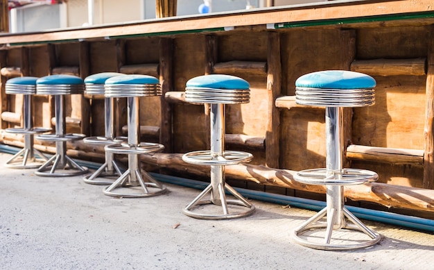 Cadeiras e mesas vazias no café da calçada contra o edifício