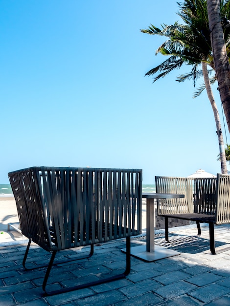 Cadeiras modernas com mesa lateral na varanda com vista para o mar
