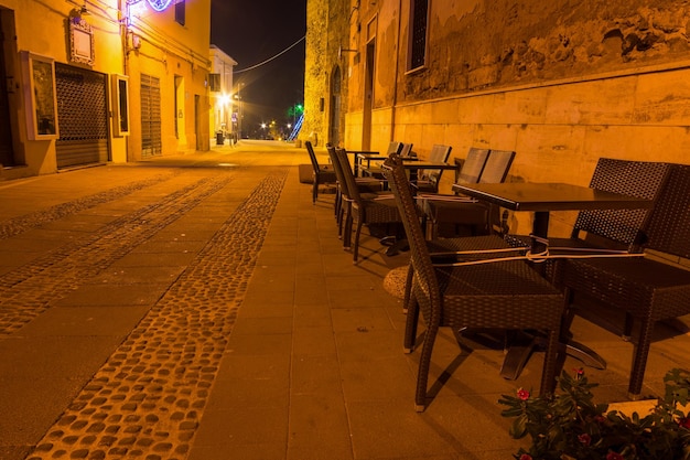 Cadeiras na cidade velha de Alghero à noite Itália