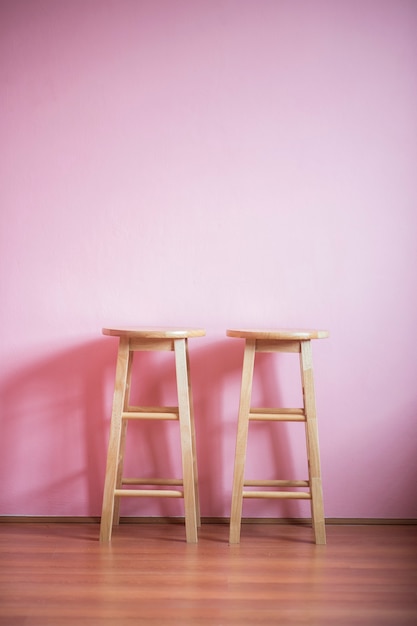cadeiras na parede rosa