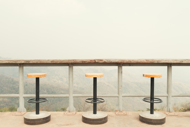 Cadeiras no terraço ensolarado com vista para a baía e decoração em casa contemporânea.