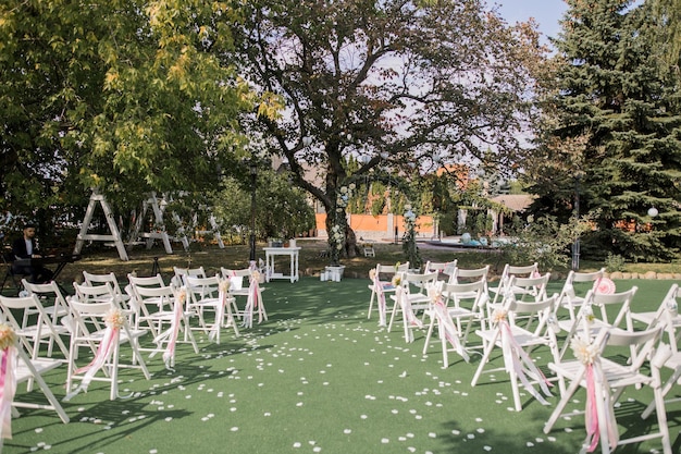 Cadeiras para uma cerimônia de casamento com decoração no parque