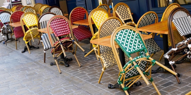 Cadeiras trançadas de restaurante parisiense ao ar livre em um terraço de bar de rua na cidade