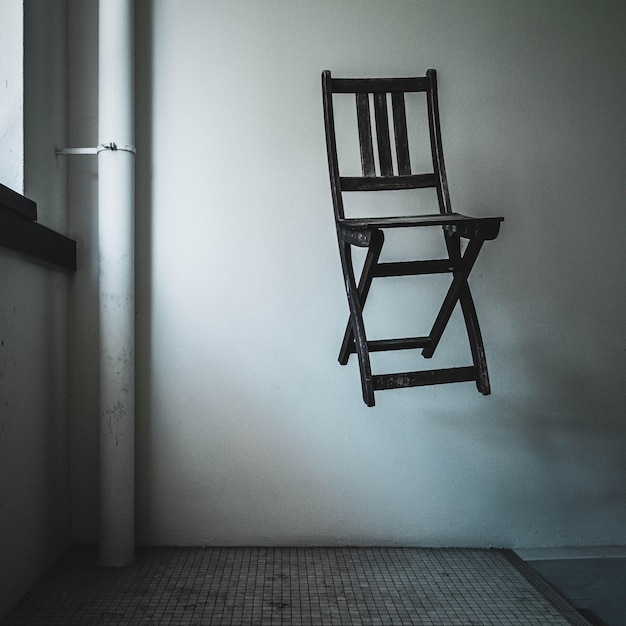 Foto cadeiras vazias e mesa contra a parede em casa