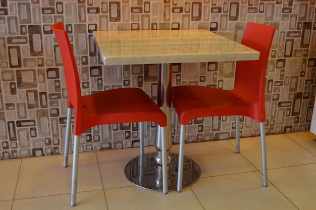 Foto cadeiras vazias e mesa contra a parede no restaurante