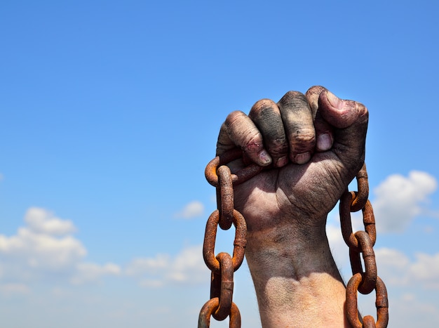 Foto cadena de hierro oxidado en mano derecha masculina humana