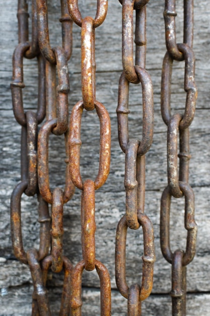 Cadena de metal oxidado en el fondo de tablas de madera Enfoque selectivo Foto vertical