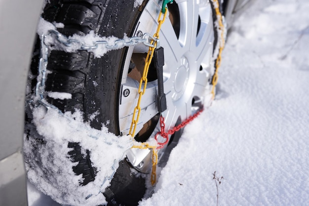 Cadena de nieve sobre una rueda en nieve profunda en invierno