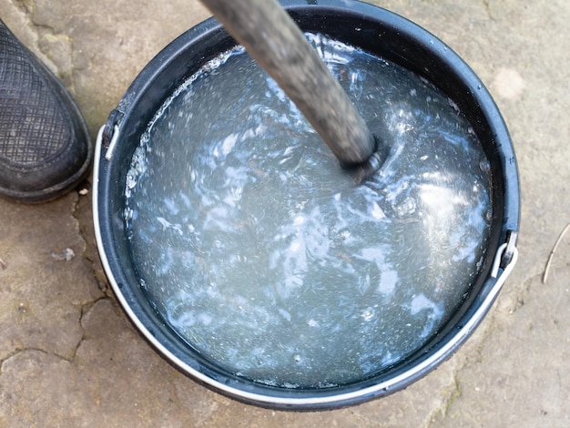 Cadena de productos químicos por palo en balde al aire libre