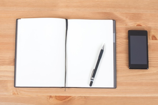 Caderno aberto com caneta e tinta na mesa de madeira