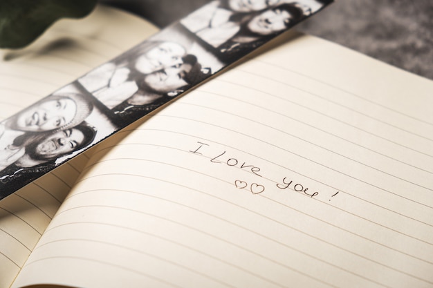 Foto caderno aberto com fotos de casal feliz