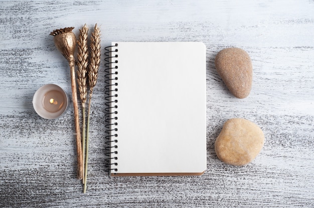 Caderno aberto vazio e flores douradas secas em fundo rústico. Cartão com espaço de cópia para o seu texto