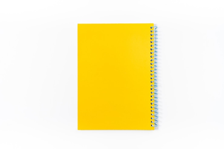 Foto caderno amarelo sobre fundo branco com traçado de recorte - imagem