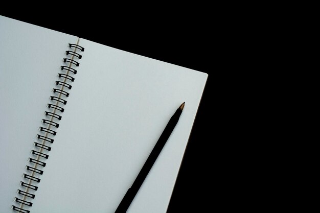 Caderno branco com fundo escuro. espaço para texto e vista superior