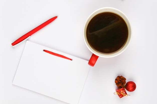 Caderno com caneta ao lado da xícara de café