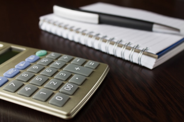 Caderno com caneta e calculadora.