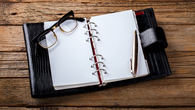 Foto caderno com caneta e óculos