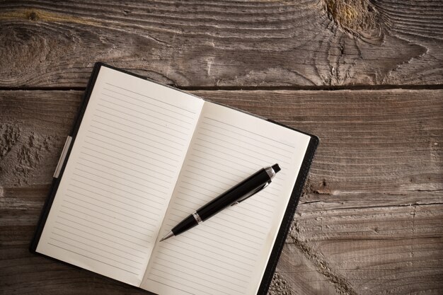 Caderno com caneta na mesa de madeira velha