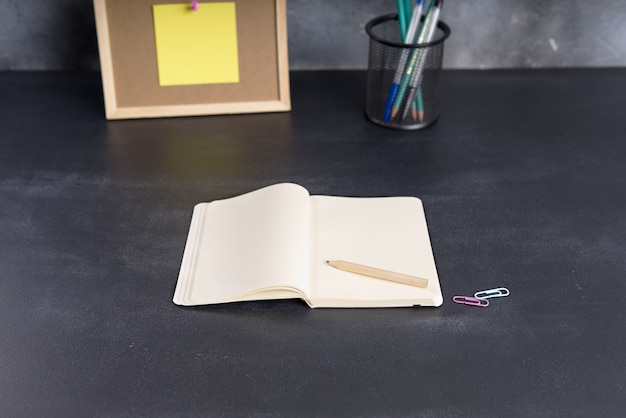 Caderno com espaço para texto em uma mesa escura de escritório