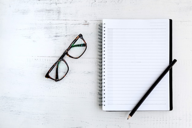 Caderno com lápis na madeira