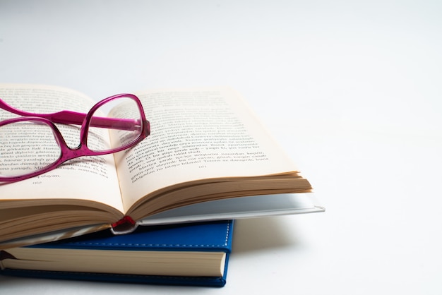 Caderno com óculos e caneta, livro com óculos, caderno azul com óculos, livro com xícara de chá