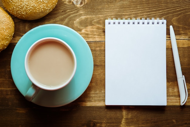 Caderno com uma caneta na mesa ao lado de cacau