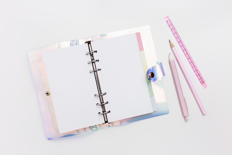 Foto caderno de anotações em espiral aberto com capa de gradiente rosa azul caneta lápis régua material de escritório rosa em fundo branco de mesa página em branco de caderno ou diário feminino para mock up de texto vista superior