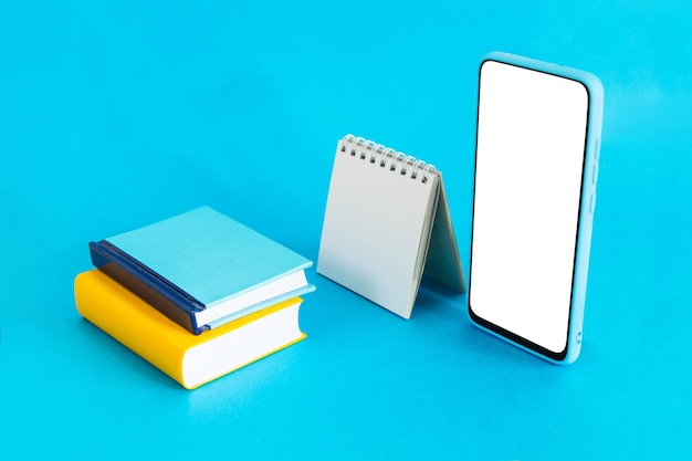 Caderno de calendário em branco e telefone inteligente em fundo azul claro Elearning e conceito de planejamento de cronograma