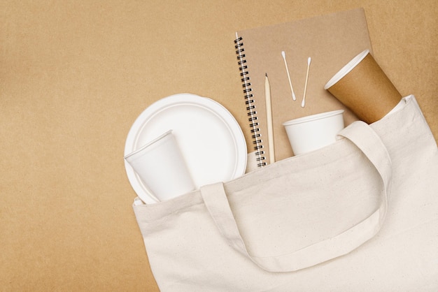 Caderno de conceito ecológico com lápis e recipiente de comida em saco ecológico em fundo de madeira