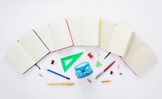 Caderno de papel e material escolar em fundo branco