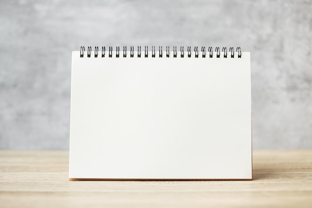 Caderno de papel em branco branco ou calendário na mesa de madeira com espaço de cópia para o seu texto, modelo e conceito de simulação