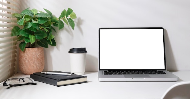 Caderno de xícara de café portátil vista frontal e planta de casa na mesa branca Tela em branco para o seu texto de anúncio