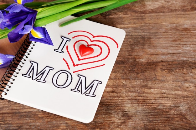 Foto caderno decorado para o dia da mãe e flores em fundo de madeira