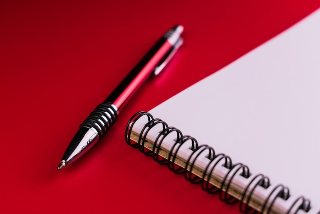 Caderno e caneta vermelha em um fundo vermelho Composição vermelha em vermelho Copie o espaço