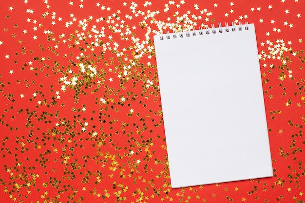 Foto caderno e confetes estrelas douradas, natal e ano novo conceito