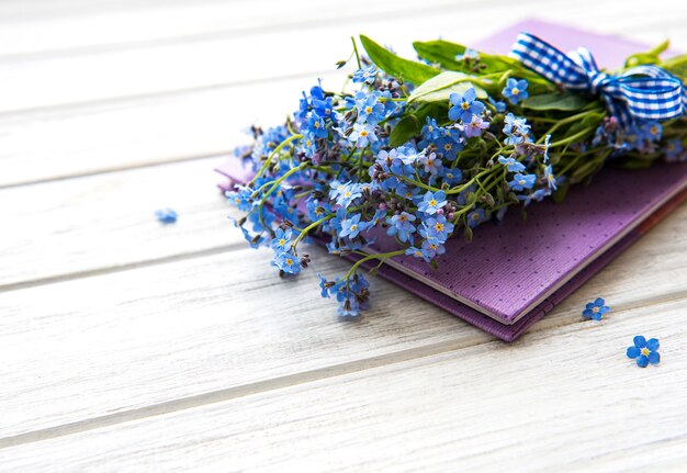 Caderno e flores de miosótis