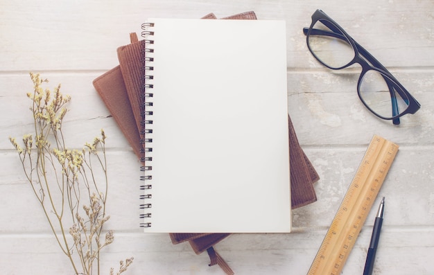 Caderno e óculos em fundo de madeira grunge com filtro vintage