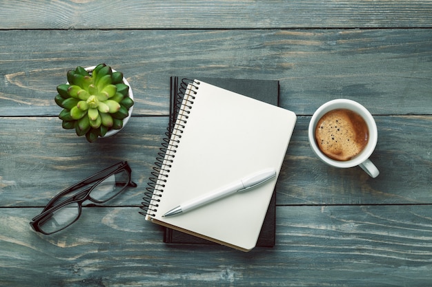 Caderno e xícara de café forte em fundo de madeira.