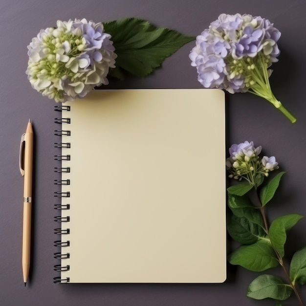 Caderno em branco com caneta e flores em fundo escuro