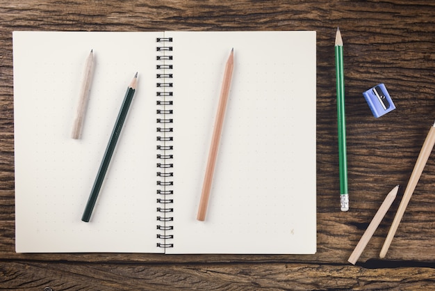 caderno em branco com caneta e lápis na mesa de madeira, o conceito de educação