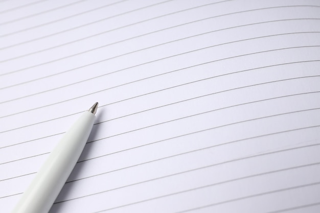 Caderno em branco com caneta em todo o fundo