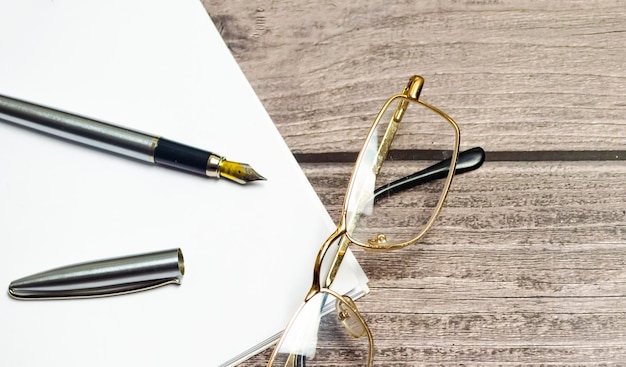 Caderno em branco com caneta está em cima da mesa de escritório branca Vista superior com espaço de cópia