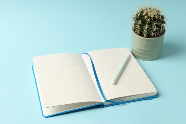 Caderno em branco e cacto em fundo azul